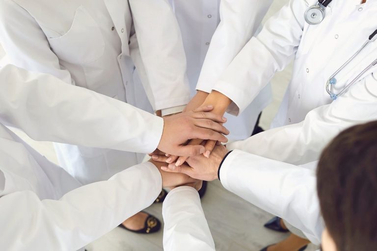 healthcare staff holding hands in a circle